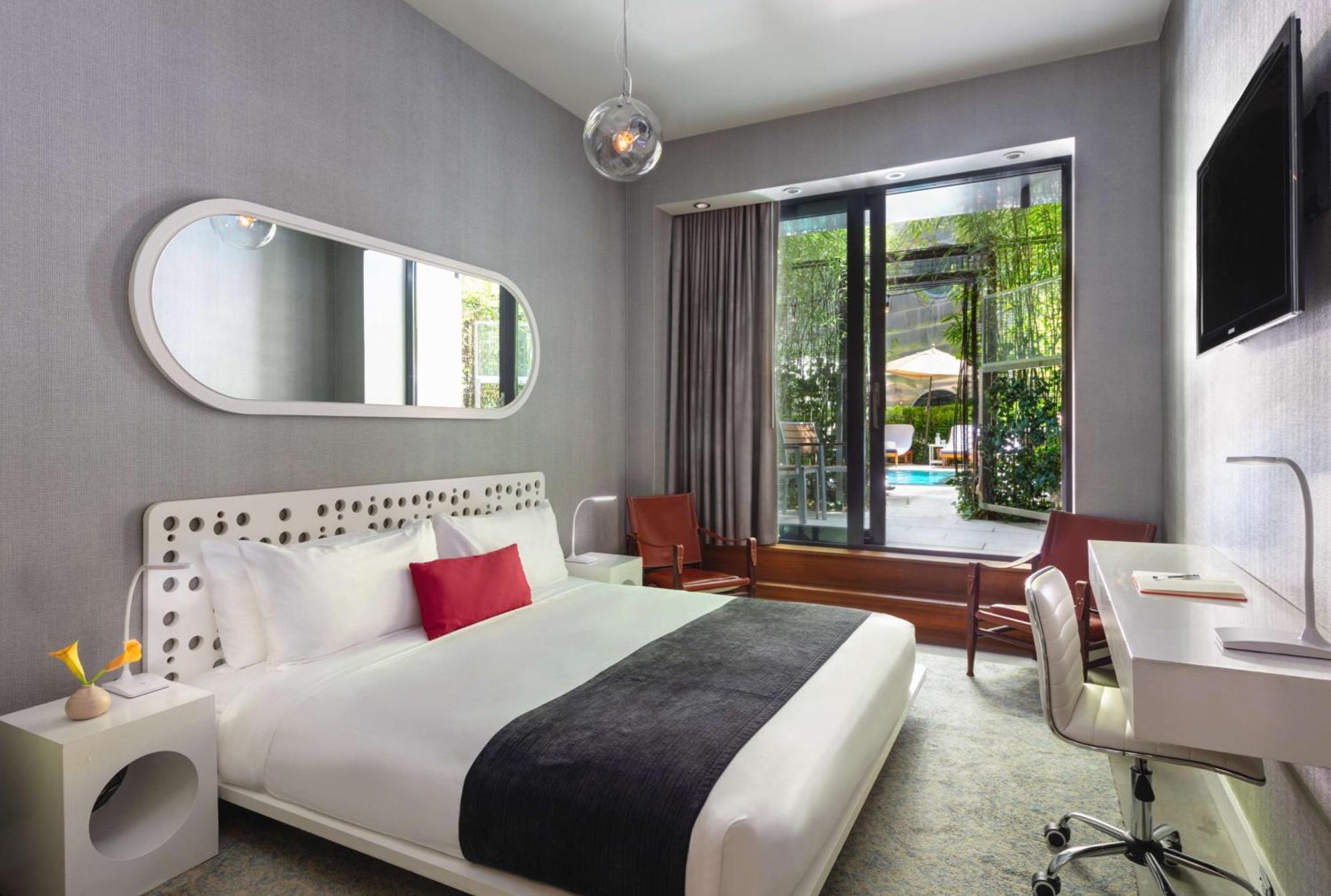 Quarto com cama king-size, chuveiro acessível a cadeirantes e acesso à piscina